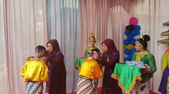 Kepala Sekolah SDN Kereo 7, Nursiah memberikan penyematan kepada siswa saat prosesi wisuda, Minggu (31/5). Dhuyuf/Bantenekspres.co.id.