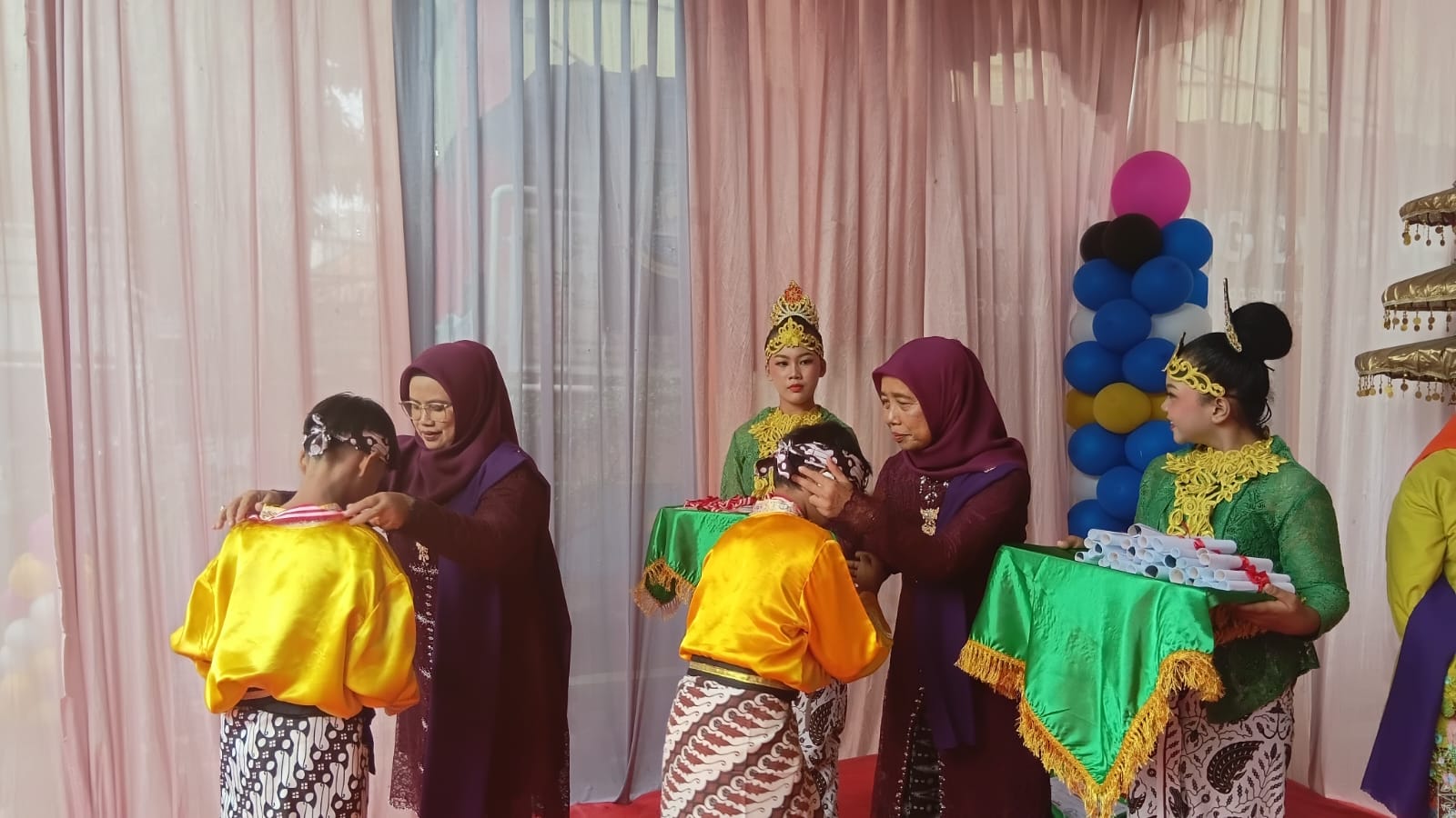 Kepala Sekolah SDN Kereo 7, Nursiah memberikan penyematan kepada siswa saat prosesi wisuda, Minggu (31/5). Dhuyuf/Bantenekspres.co.id.