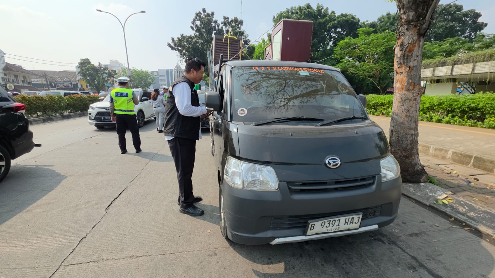 Kepala Seksi Penerimaan dan Penagihan UPTD PPD Samsat Ciputat memeriksa masa berlaku STNK pengendara saat razia pajak kendaraan bermotor di Jalan Siliwangi, Pamulang. Tri Budi/Bantenekspres.co.id